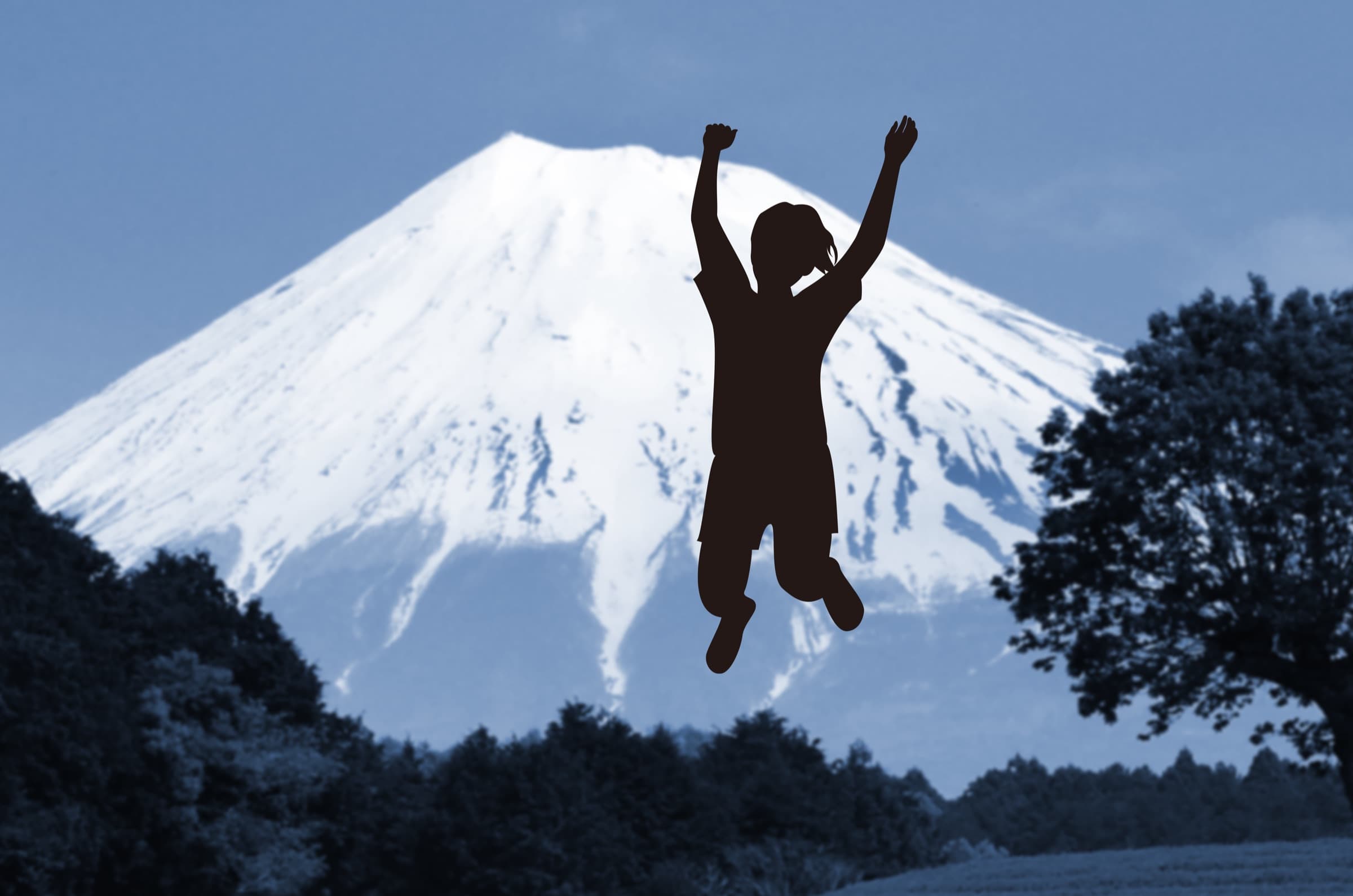 富士山と、両手を上げて喜ぶ人のシルエット